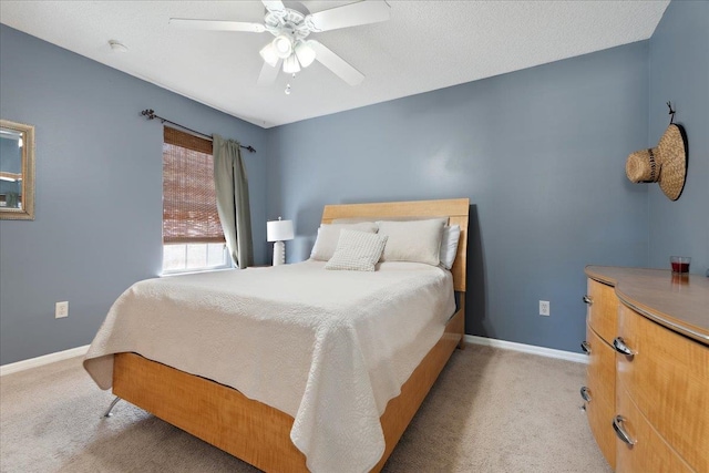 carpeted bedroom featuring baseboards and ceiling fan