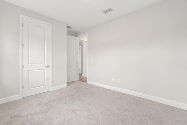 unfurnished bedroom with carpet flooring, baseboards, and visible vents