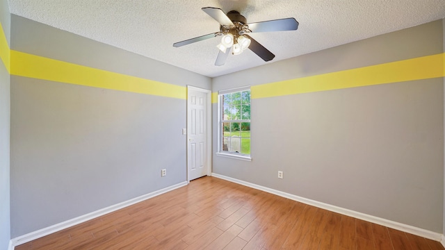 unfurnished room featuring a textured ceiling, baseboards, and wood finished floors