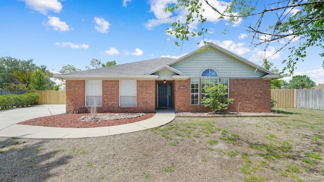 ranch-style home featuring fence and brick siding