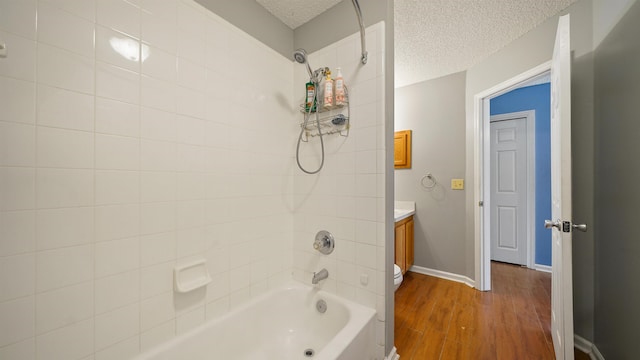full bathroom featuring baseboards, a textured ceiling, vanity, shower / bath combination, and wood finished floors