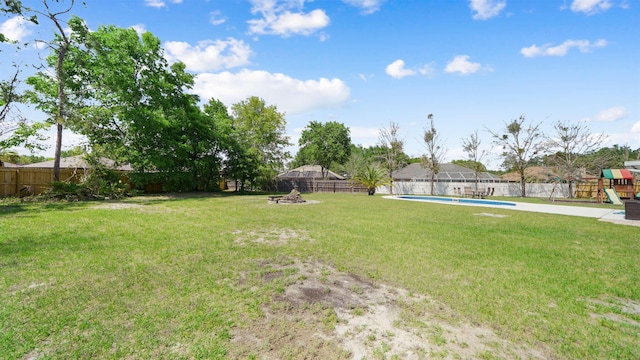 view of yard with a fenced in pool, a fenced backyard, and a playground