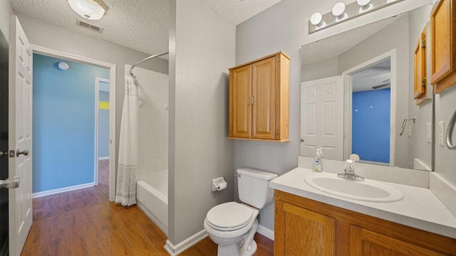 bathroom featuring visible vents, a textured ceiling, toilet, and wood finished floors