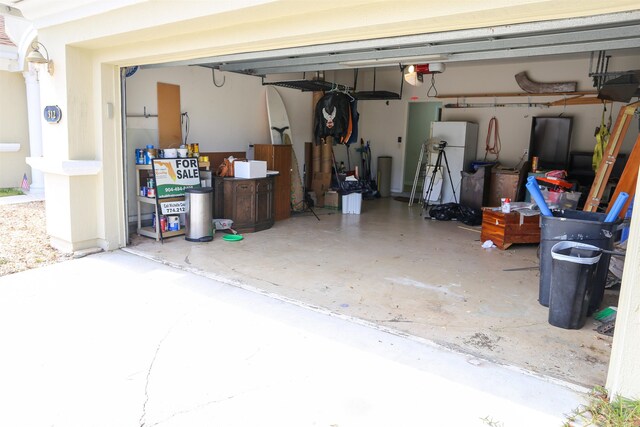 312 Brantley Harbor Dr, Saint Augustine, FL 32086 - garage with a garage door opener and freestanding refrigerator