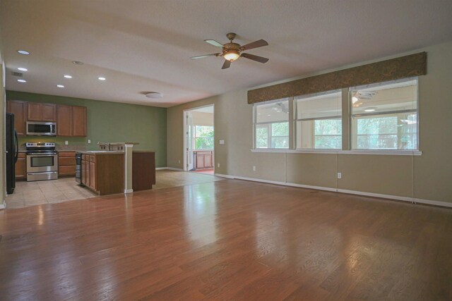 312 Brantley Harbor Dr, Saint Augustine, FL 32086 - unfurnished living room with baseboards, a sink, light wood-style flooring, and a ceiling fan