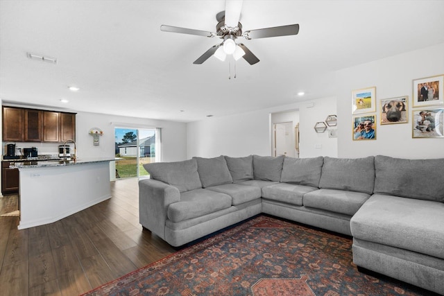 living room featuring dark hardwood / wood-style flooring and ceiling fan