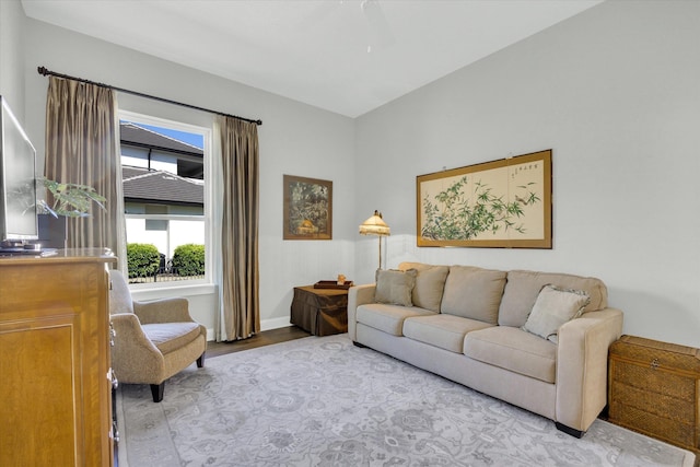 living room featuring baseboards, ceiling fan, and wood finished floors