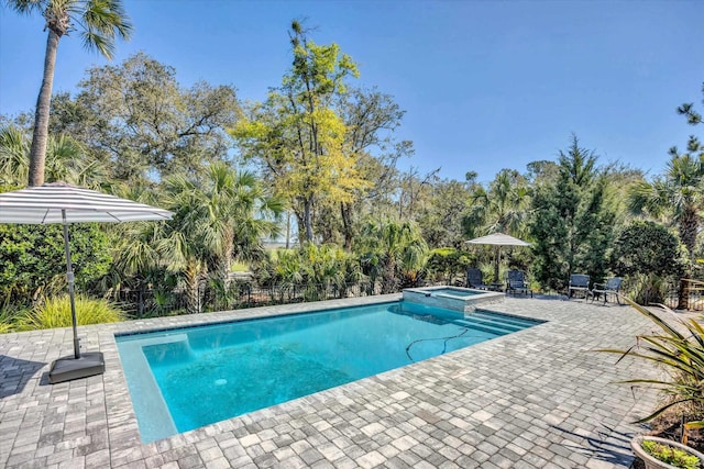 view of pool featuring a patio area, a pool with connected hot tub, and fence