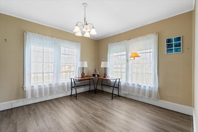 office featuring wood-type flooring, ornamental molding, and an inviting chandelier