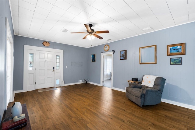 living area with wood walls, dark hardwood / wood-style floors, a healthy amount of sunlight, and ceiling fan