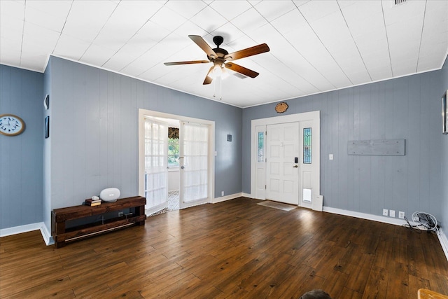 entryway with wooden walls, ceiling fan, and dark hardwood / wood-style floors