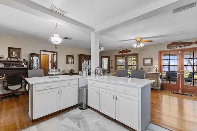 kitchen with kitchen peninsula, ceiling fan, french doors, and white cabinets