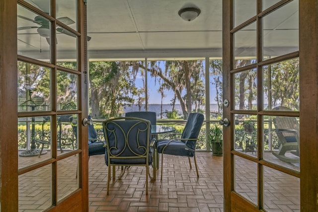 unfurnished sunroom with ceiling fan