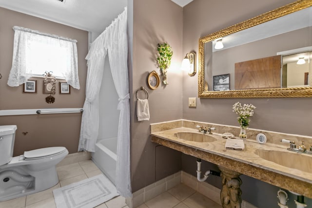 bathroom featuring tile patterned flooring, shower / bath combo, toilet, and double sink