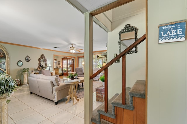 living room with ceiling fan, crown molding, and light tile patterned flooring