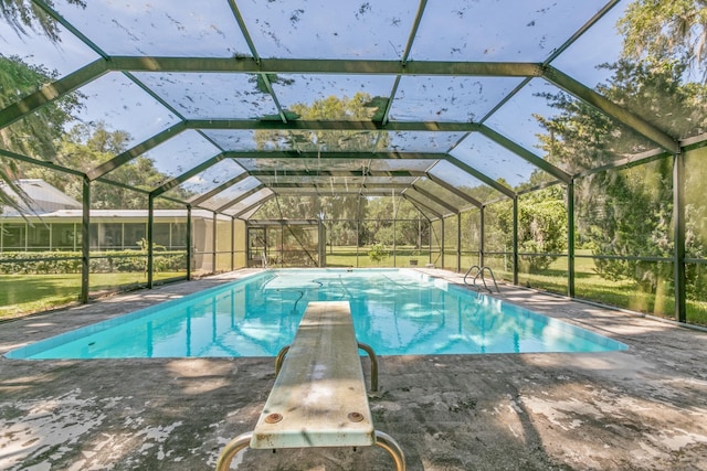 view of swimming pool featuring a patio, glass enclosure, and a diving board