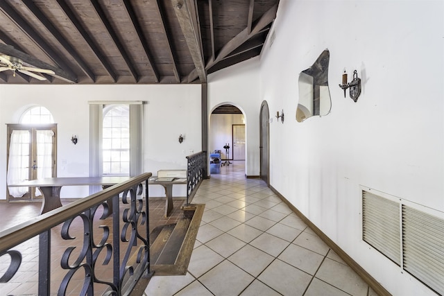 hall featuring lofted ceiling with beams, french doors, light tile patterned floors, and wooden ceiling