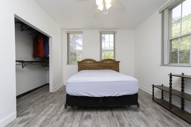 bedroom featuring light hardwood / wood-style flooring, multiple windows, and ceiling fan