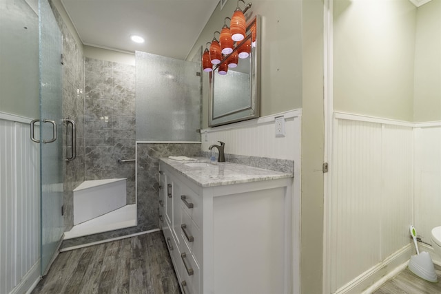 bathroom featuring wood-type flooring, vanity, toilet, and an enclosed shower