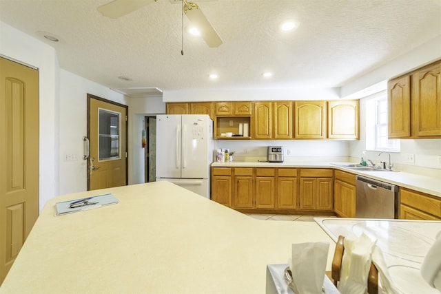 kitchen featuring dishwasher, white refrigerator, sink, ceiling fan, and a textured ceiling