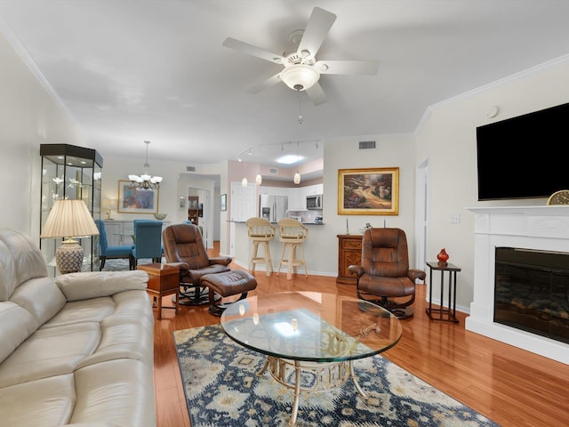 living room featuring ornamental molding, visible vents, and light wood-style floors