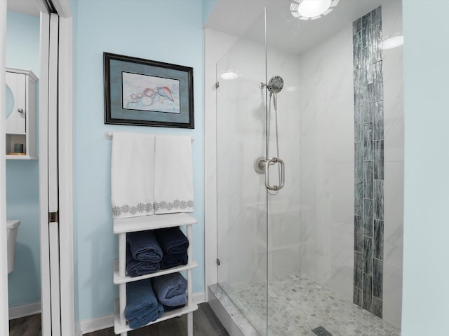 bathroom with hardwood / wood-style flooring, toilet, and an enclosed shower