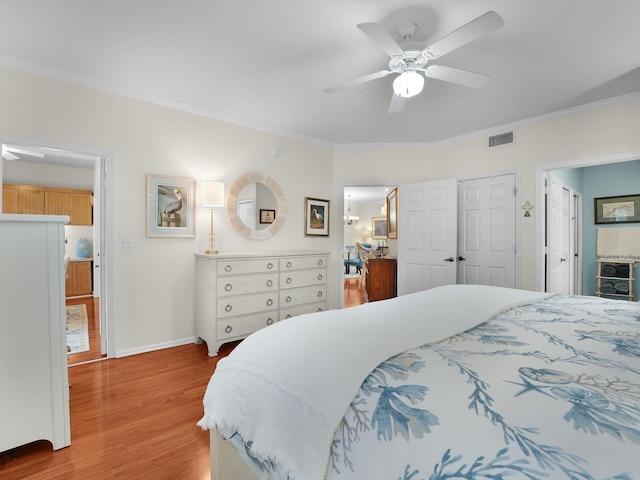 bedroom with light wood-type flooring, baseboards, visible vents, and crown molding