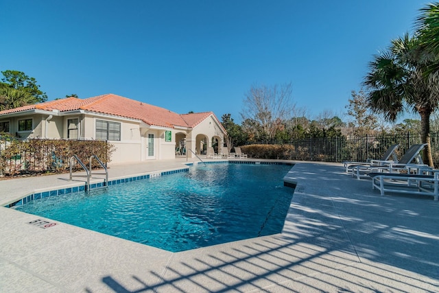 pool featuring fence and a patio