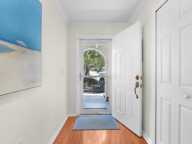 entryway featuring crown molding, baseboards, and light wood-style floors