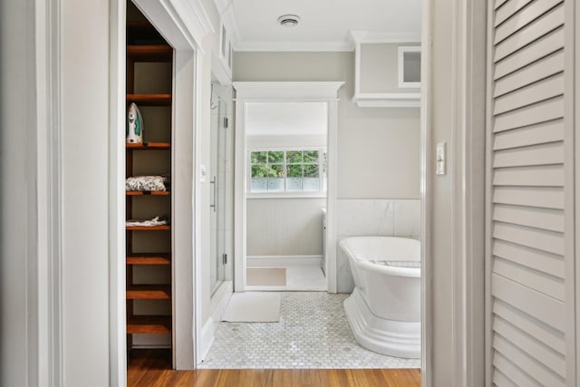 127 M L King Ave, Saint Augustine, FL 32084 - full bath with ornamental molding, a freestanding tub, a stall shower, a closet, and a wainscoted wall