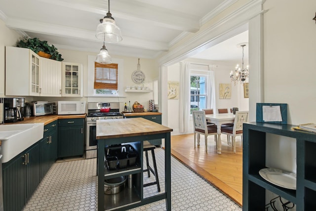 127 M L King Ave, Saint Augustine, FL 32084 - kitchen featuring wood counters, stainless steel gas range oven, white microwave, beamed ceiling, and ornamental molding