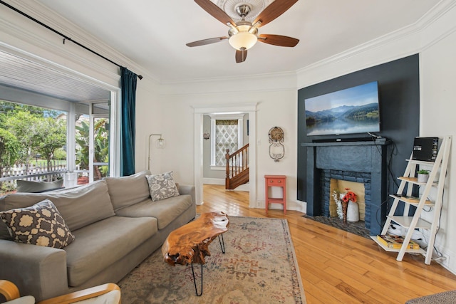 127 M L King Ave, Saint Augustine, FL 32084 - living area featuring crown molding, light wood-type flooring, ceiling fan, a fireplace with flush hearth, and baseboards