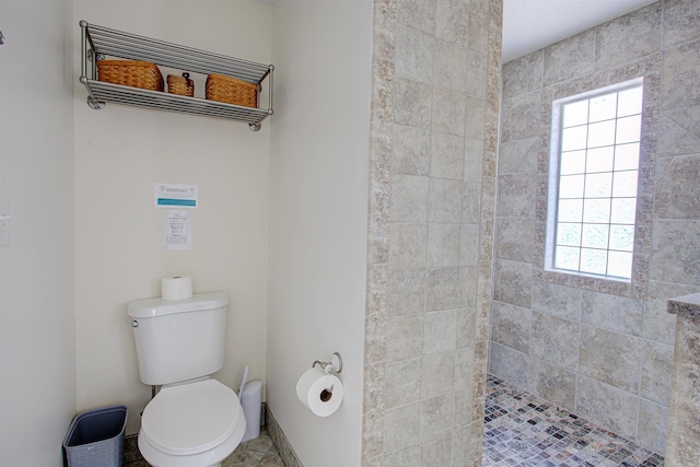 bathroom featuring a tile shower and toilet