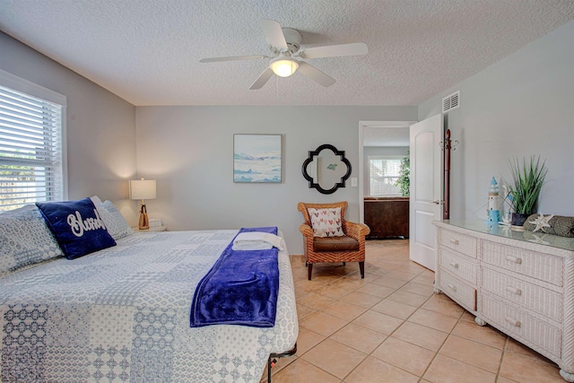 bedroom featuring light tile patterned flooring, a textured ceiling, multiple windows, and ceiling fan