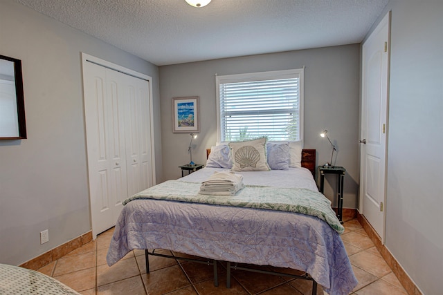 tiled bedroom featuring a textured ceiling and a closet