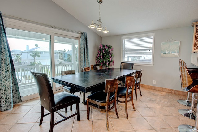 tiled dining area featuring a healthy amount of sunlight and vaulted ceiling