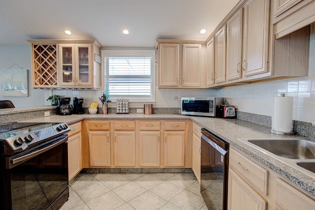 kitchen with light tile patterned flooring, light brown cabinets, and black appliances