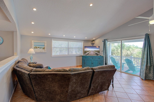 tiled living room with a textured ceiling, vaulted ceiling, and ceiling fan