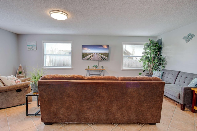 tiled living room featuring a healthy amount of sunlight and a textured ceiling