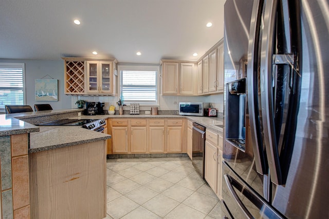 kitchen with black appliances, stone countertops, light brown cabinets, and light tile patterned floors