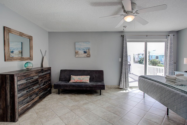 tiled bedroom with ceiling fan, a textured ceiling, and access to outside