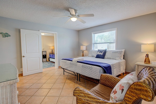 tiled bedroom with ceiling fan and a textured ceiling