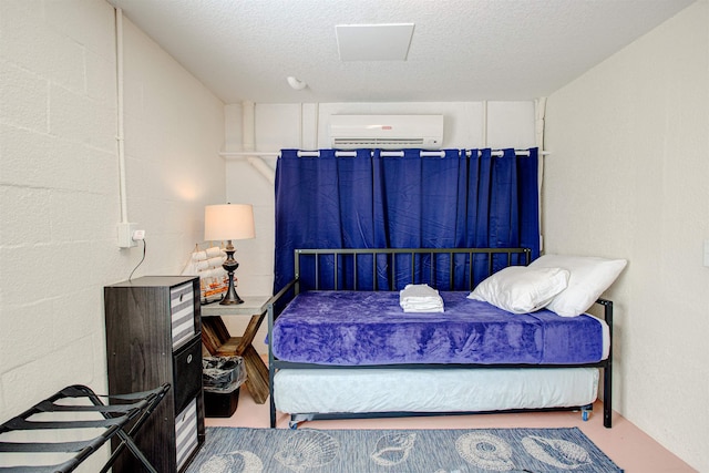 bedroom with an AC wall unit and a textured ceiling