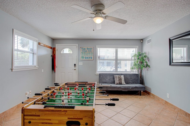 playroom featuring a textured ceiling, tile patterned floors, a wealth of natural light, and ceiling fan