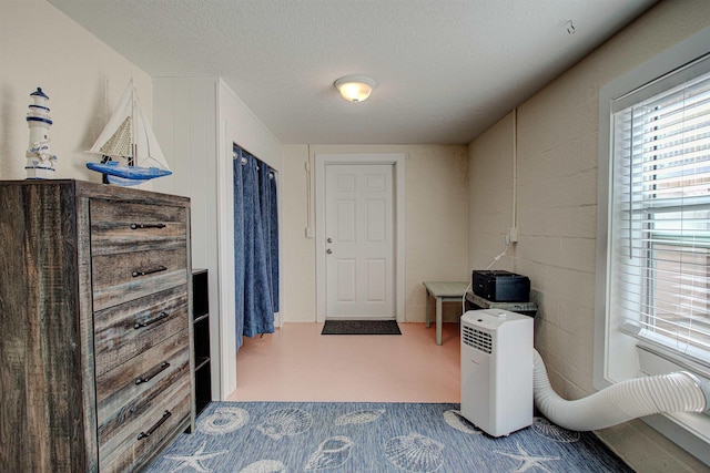 interior space featuring dark carpet and a textured ceiling