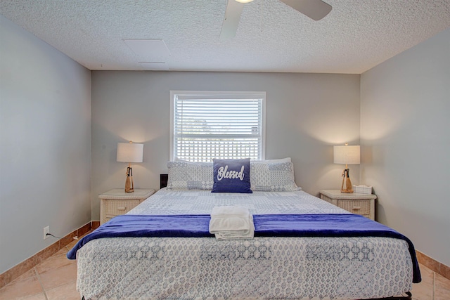 bedroom featuring ceiling fan, light tile patterned floors, and a textured ceiling