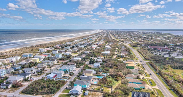 birds eye view of property featuring a water view and a beach view