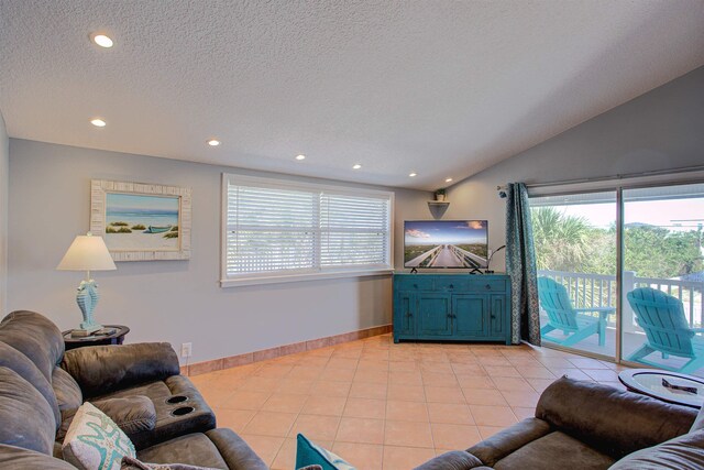 living room featuring a textured ceiling, light tile patterned floors, and vaulted ceiling