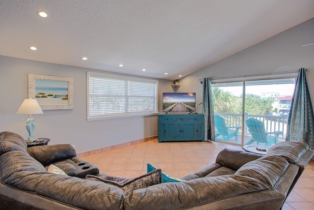 living room featuring lofted ceiling, light tile patterned floors, and a textured ceiling