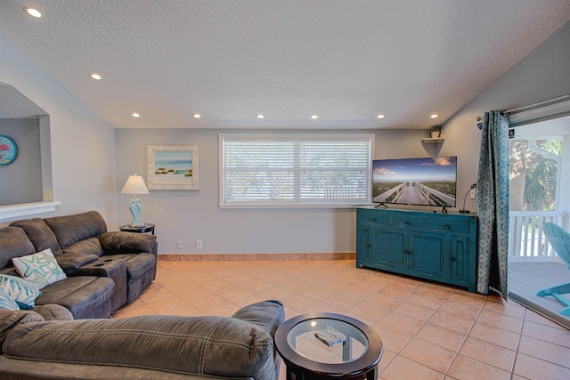 living room featuring a wealth of natural light, light tile patterned flooring, and a textured ceiling